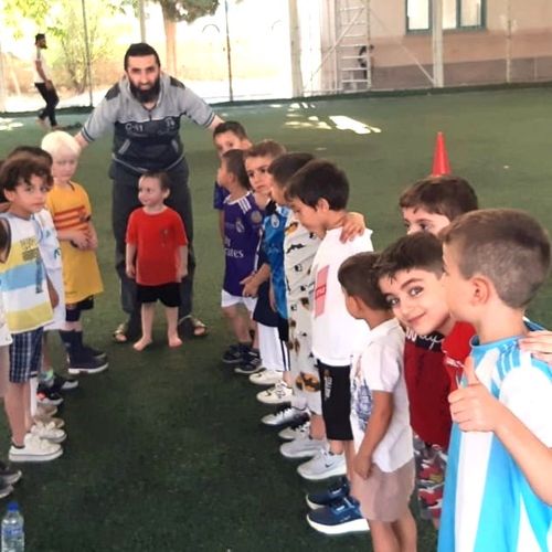 A group photo of our dear children on the football field.